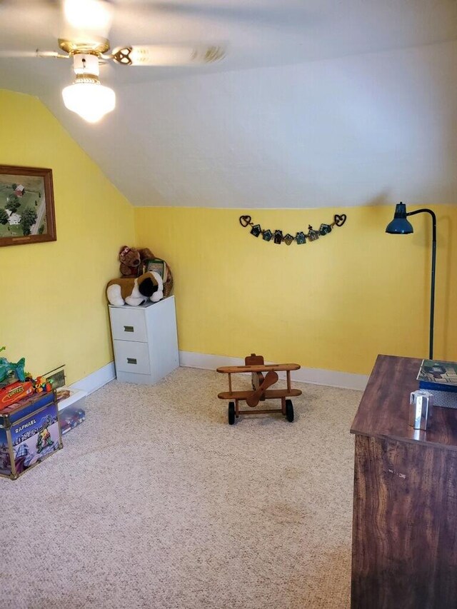 sitting room with vaulted ceiling, ceiling fan, and carpet flooring