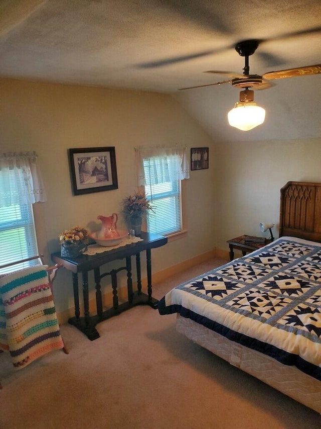 carpeted bedroom featuring ceiling fan, a textured ceiling, and vaulted ceiling