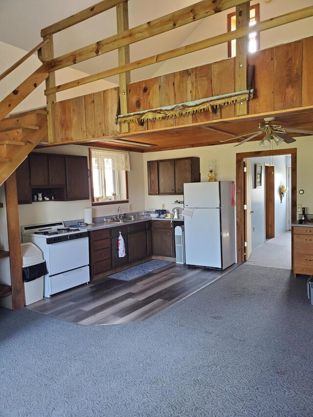 kitchen featuring white appliances, dark carpet, sink, and ceiling fan