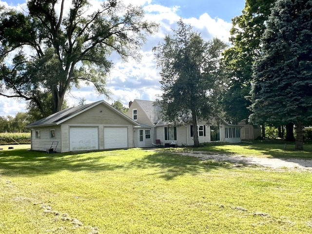 view of front of home featuring an attached garage, an outdoor structure, and a front lawn