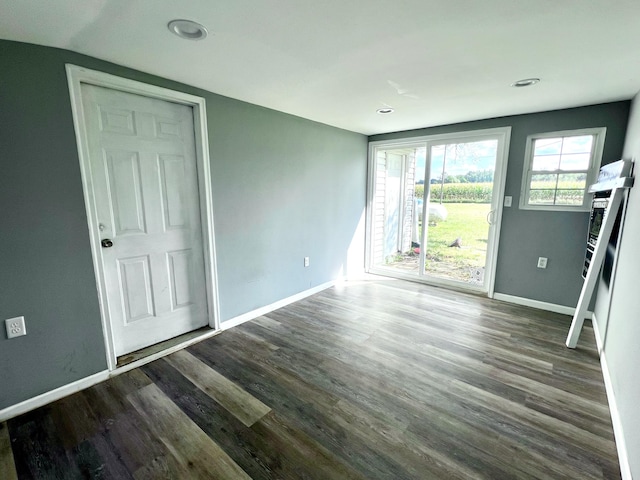 interior space with access to exterior, wood finished floors, and baseboards