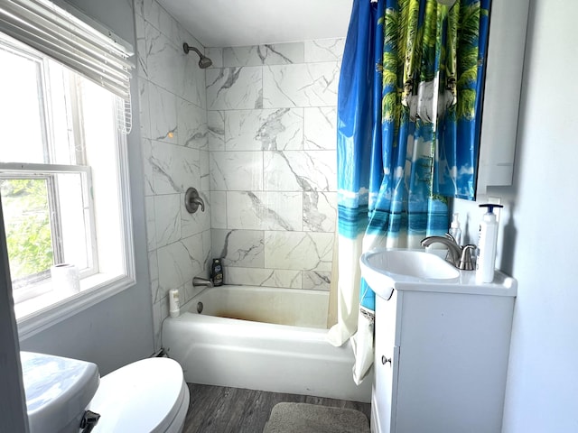 bathroom featuring toilet, wood finished floors, vanity, and shower / bath combination with curtain