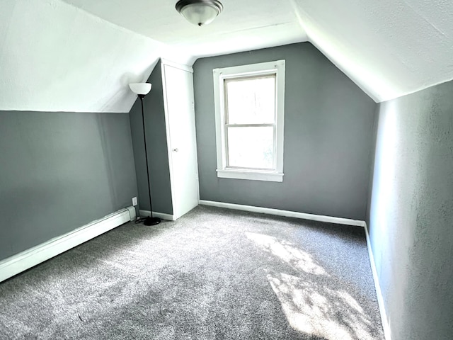 additional living space featuring vaulted ceiling, carpet flooring, baseboards, and a baseboard radiator