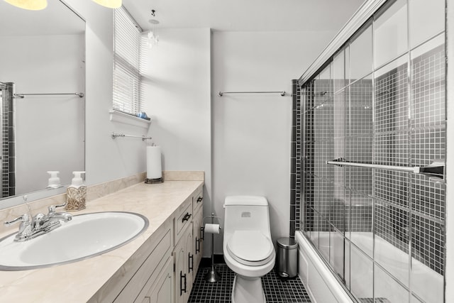 full bathroom featuring combined bath / shower with glass door, vanity, toilet, and tile patterned flooring