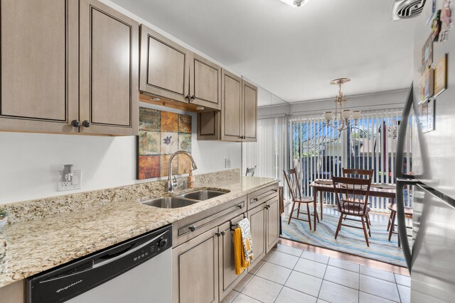 kitchen featuring light stone countertops, light tile patterned floors, appliances with stainless steel finishes, sink, and a chandelier