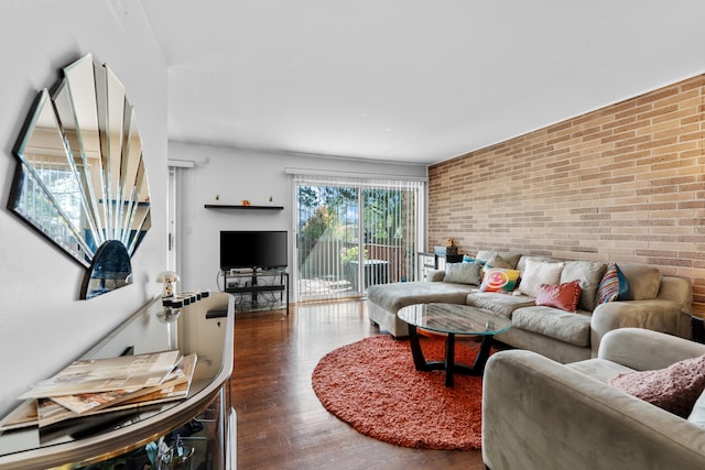 living room featuring hardwood / wood-style flooring and brick wall