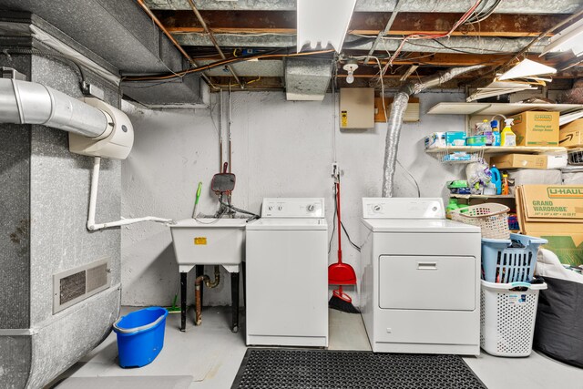 laundry area with washing machine and clothes dryer and sink