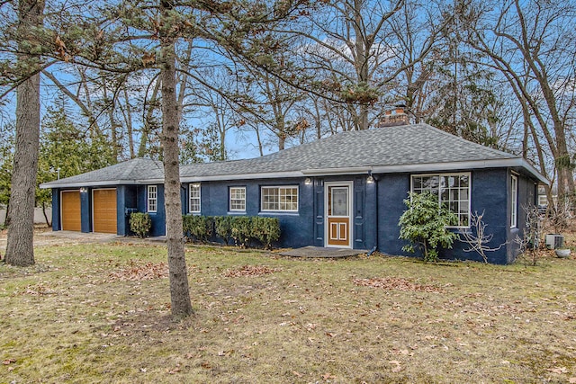 single story home featuring a front lawn, central AC unit, and a garage