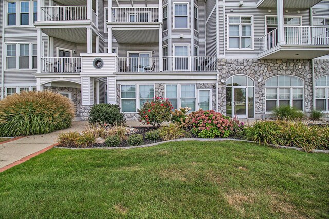 exterior space featuring a lawn and a balcony