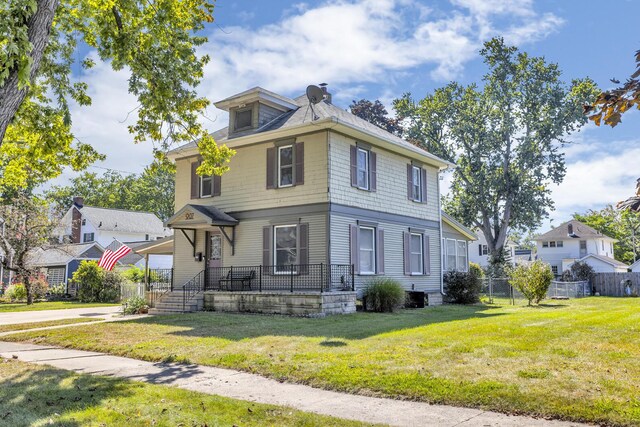 view of front of house featuring central AC and a front yard