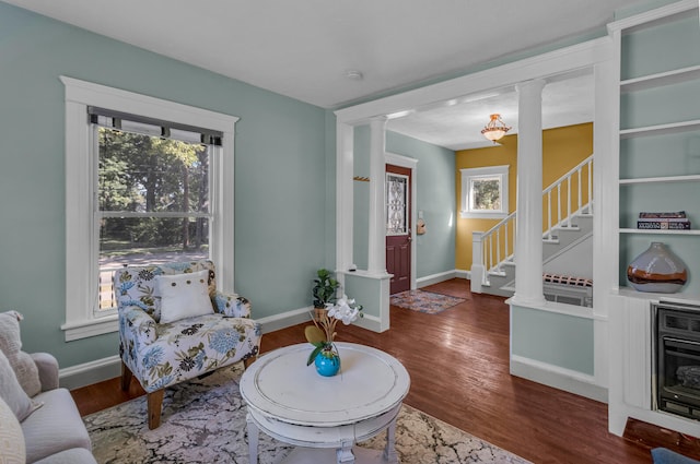 sitting room featuring plenty of natural light, dark hardwood / wood-style floors, and ornate columns