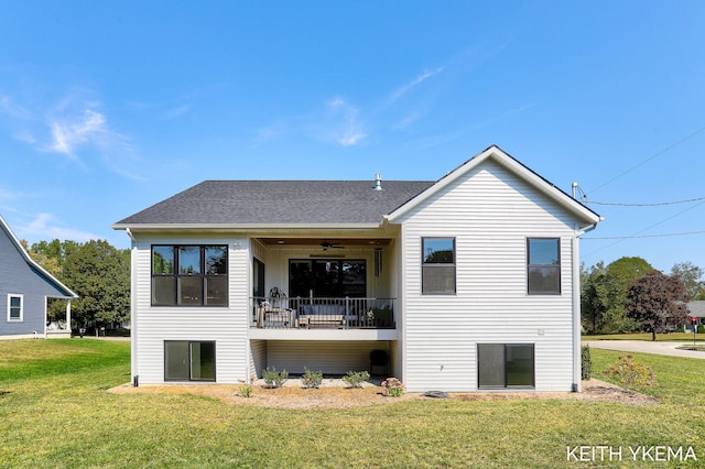 back of property with ceiling fan and a yard