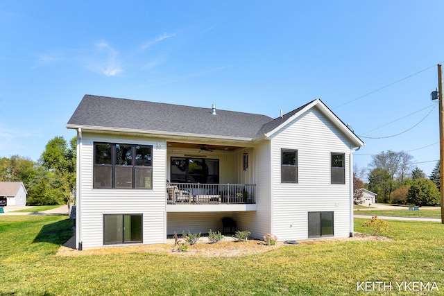 rear view of property featuring a yard and ceiling fan