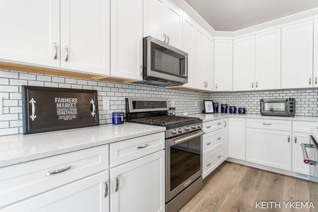 kitchen featuring light hardwood / wood-style flooring, appliances with stainless steel finishes, and white cabinetry