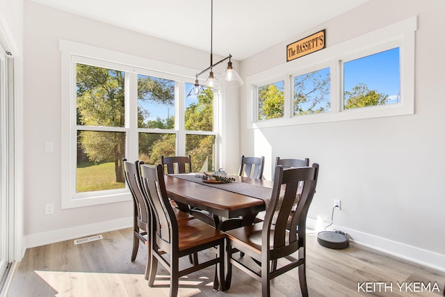 dining space featuring an inviting chandelier and light hardwood / wood-style floors