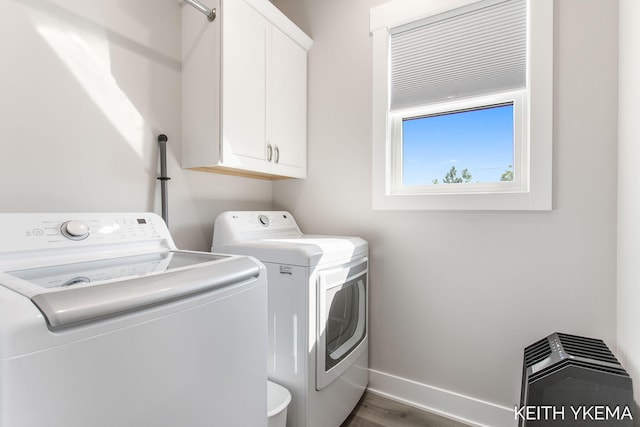 washroom with cabinets, dark wood-type flooring, and separate washer and dryer