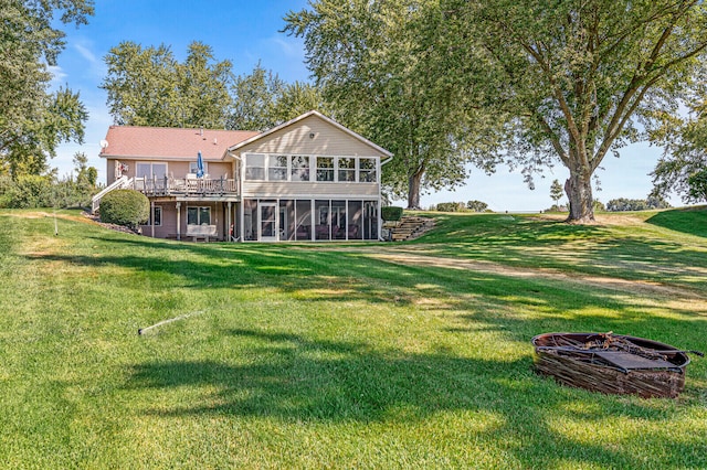 back of house with a sunroom and a lawn