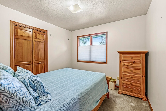 bedroom featuring light colored carpet and a textured ceiling