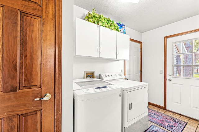 washroom featuring cabinets, a textured ceiling, washing machine and dryer, and light tile patterned flooring