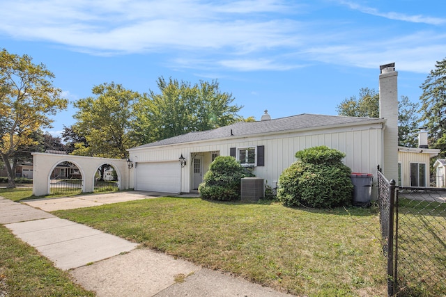 ranch-style home featuring a garage, central AC unit, and a front yard