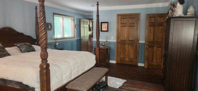 bedroom with crown molding and dark hardwood / wood-style flooring