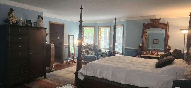 bedroom with dark wood-type flooring, crown molding, and a textured ceiling