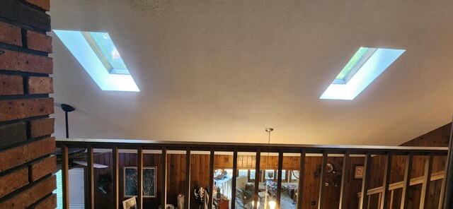 stairs featuring vaulted ceiling with skylight and a textured ceiling