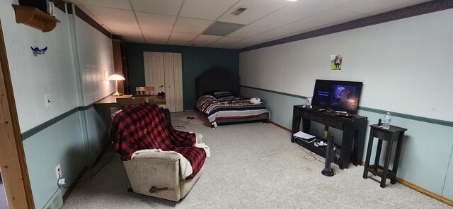 carpeted bedroom featuring a drop ceiling