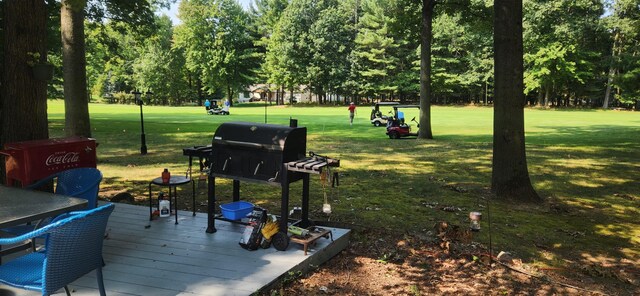 view of community featuring a yard and a wooden deck