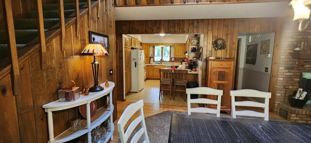 dining area with light hardwood / wood-style flooring and wooden walls