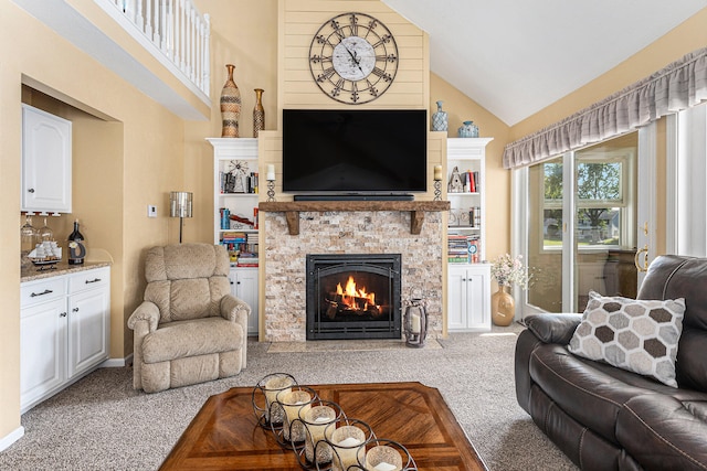 carpeted living room with a stone fireplace and high vaulted ceiling