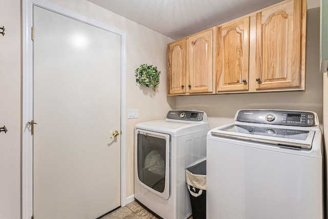 clothes washing area featuring cabinets, light tile patterned floors, washer and clothes dryer, and a textured ceiling