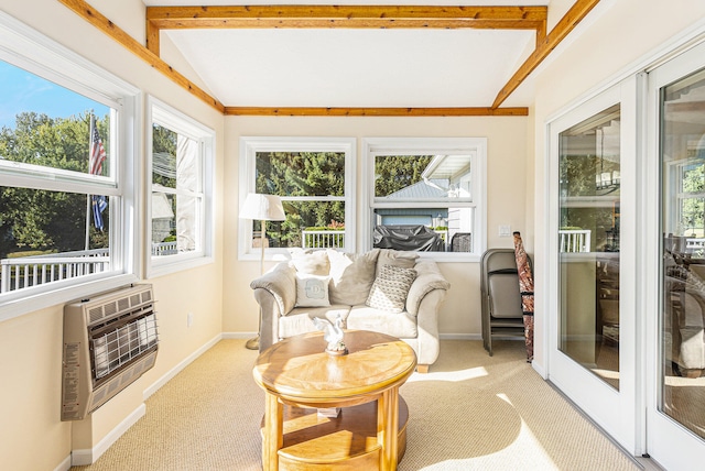 sunroom featuring lofted ceiling with beams, plenty of natural light, and heating unit