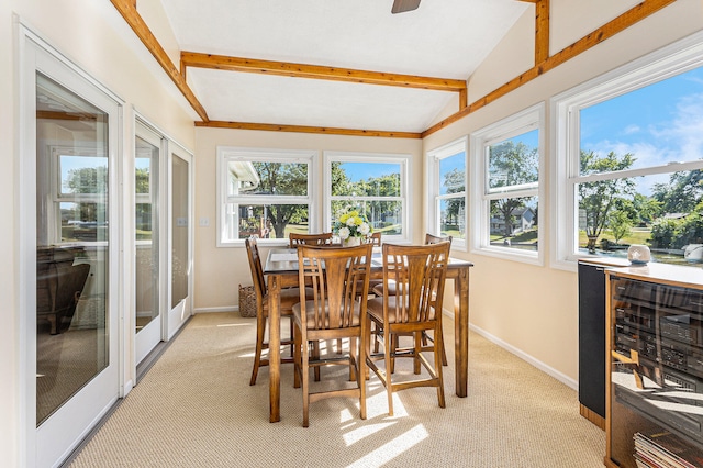 sunroom / solarium featuring vaulted ceiling with beams