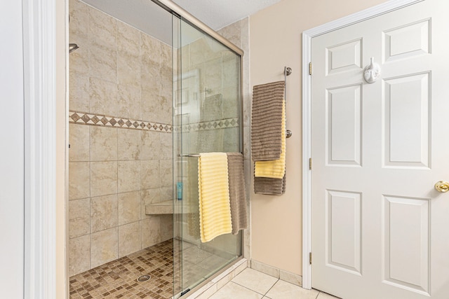 bathroom with tile patterned flooring and a shower with door