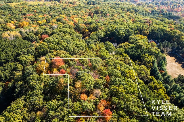 birds eye view of property featuring a view of trees