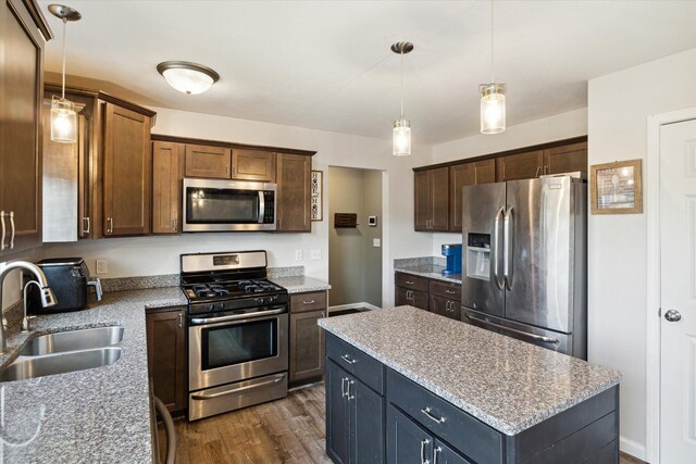 kitchen featuring sink, a center island, stainless steel appliances, dark hardwood / wood-style flooring, and pendant lighting