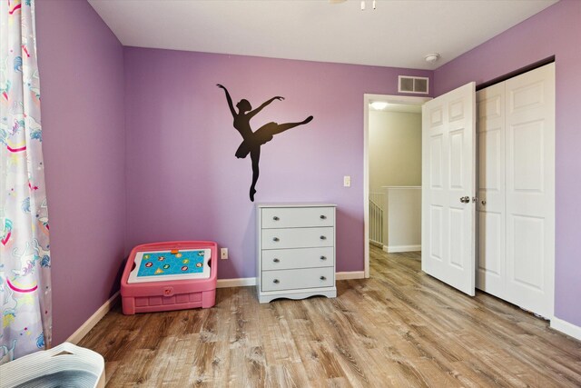 bedroom with light hardwood / wood-style flooring and a closet