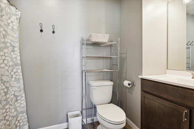 bathroom with vanity, toilet, and wood-type flooring