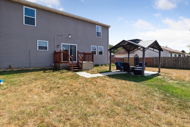 rear view of property with a gazebo, an outdoor living space, a patio area, and a lawn