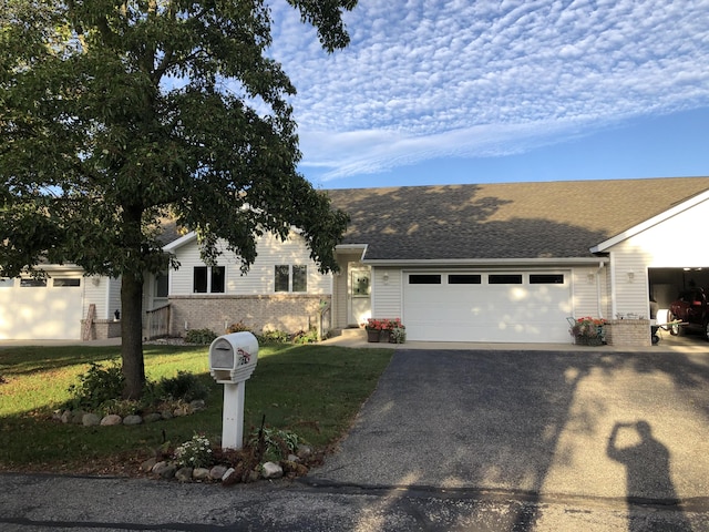 single story home featuring a garage and a front yard