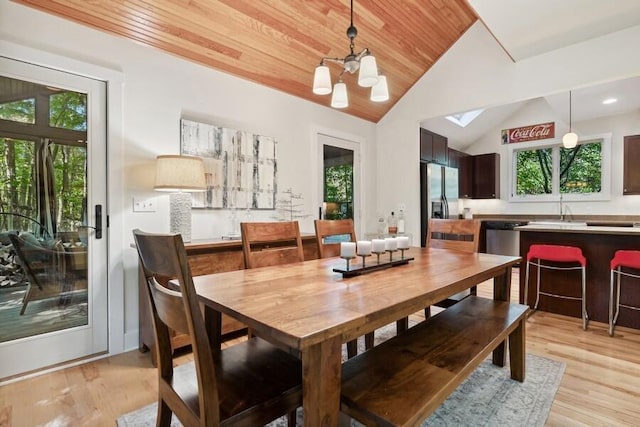 dining room with sink, wooden ceiling, a notable chandelier, vaulted ceiling, and light wood-type flooring