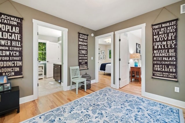 bedroom featuring ensuite bathroom and light hardwood / wood-style flooring