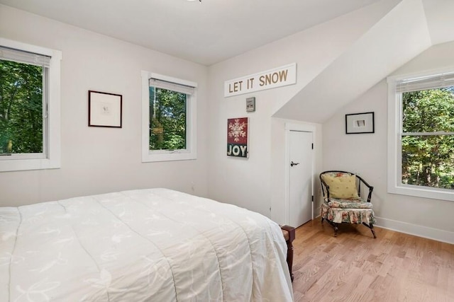 bedroom featuring lofted ceiling and light wood-type flooring