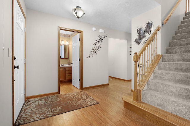 foyer featuring light wood-type flooring and a textured ceiling