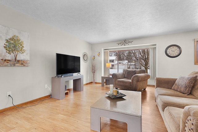 living room with light hardwood / wood-style floors and a textured ceiling