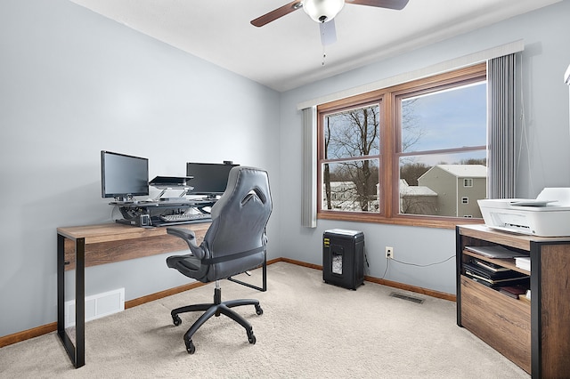 carpeted office space with ceiling fan