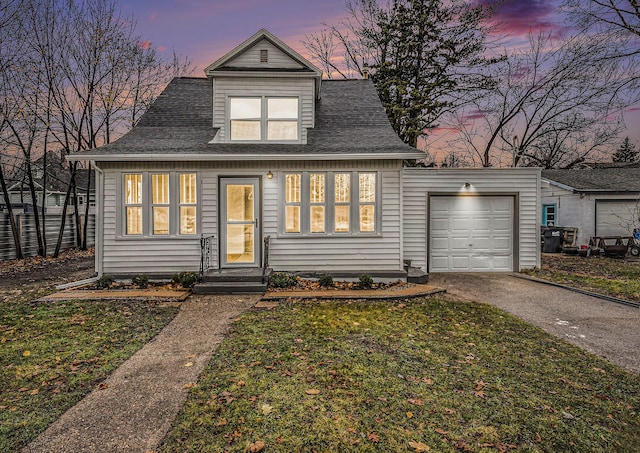 view of front of house featuring a garage and a lawn