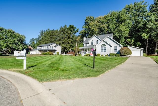 view of front facade featuring a garage, an outbuilding, and a front lawn