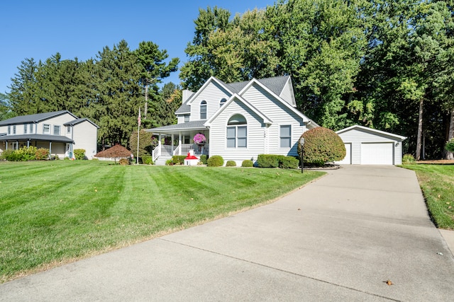 view of front of home with an outbuilding, a porch, a front yard, and a garage